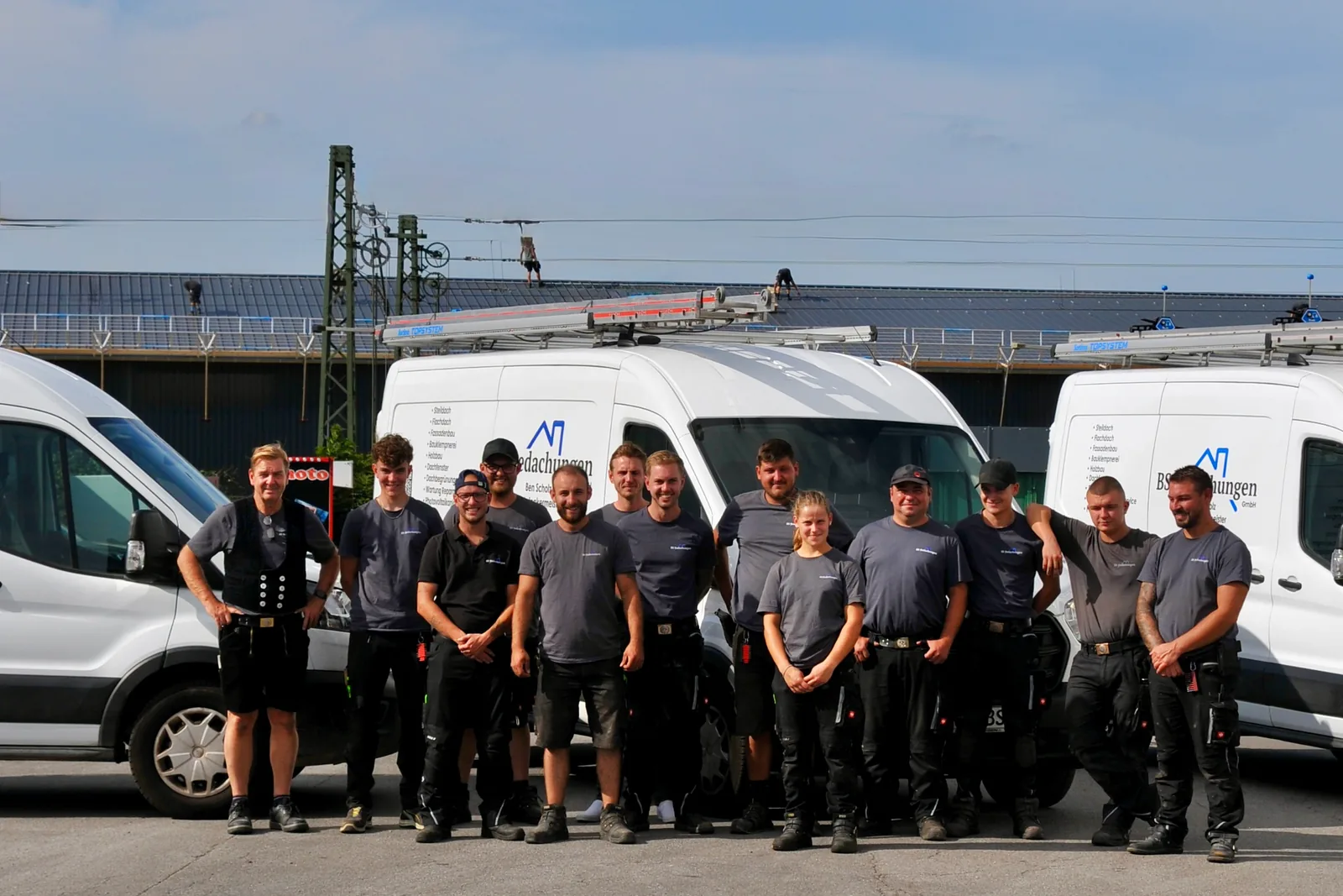 Das Team von BS Bedachungen vor den Firmentransportern auf dem Betriebshof in Willich